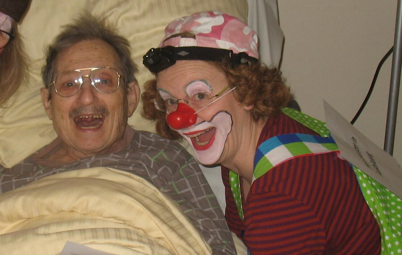 Pauline Pillepalle besucht einen lachenden Bewohner am Bett